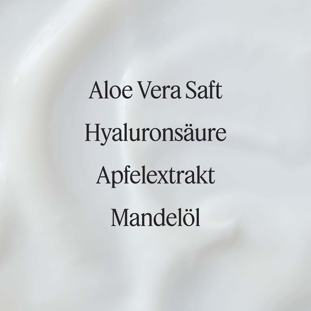 Gros plan sur la crème. Texte : Jus d'Aloe Vera, Acide hyaluronique, Extrait de pomme, Huile d'amande. Texture crémeuse blanche.