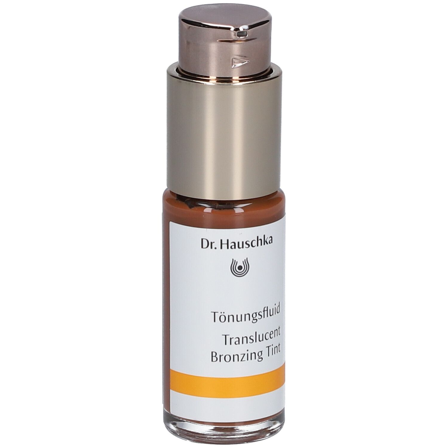 Fluide teinté brun dans un flacon avec pompe argentée. Inscription : Dr. Hauschka, Tönungsfluid, Translucent Bronzing Tint.