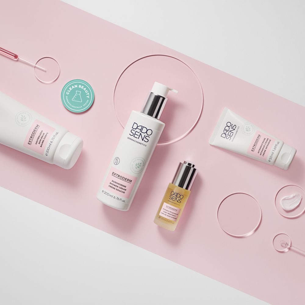 Différents produits DADO SENS. Fond rose. Flacons, tube, huile.