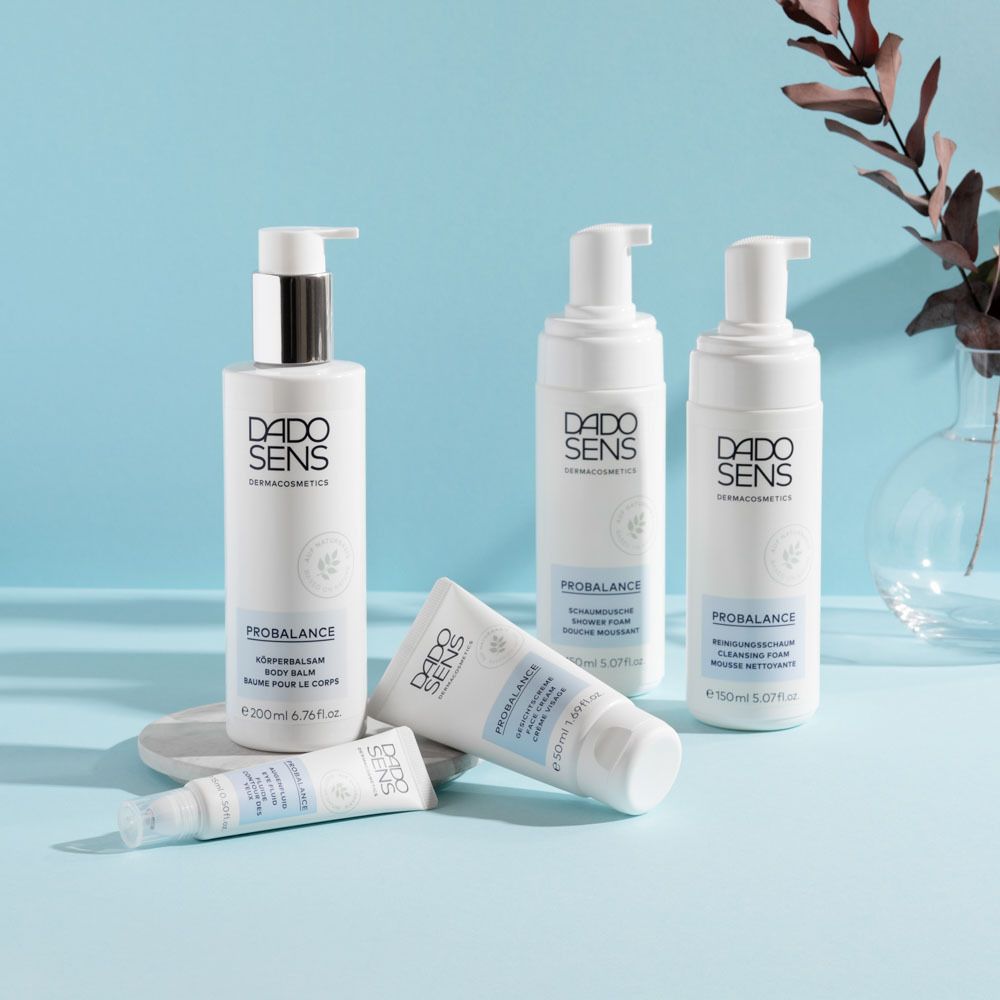 Divers produits DADO SENS. Flacons, tube, vaporisateur. Sur fond bleu.