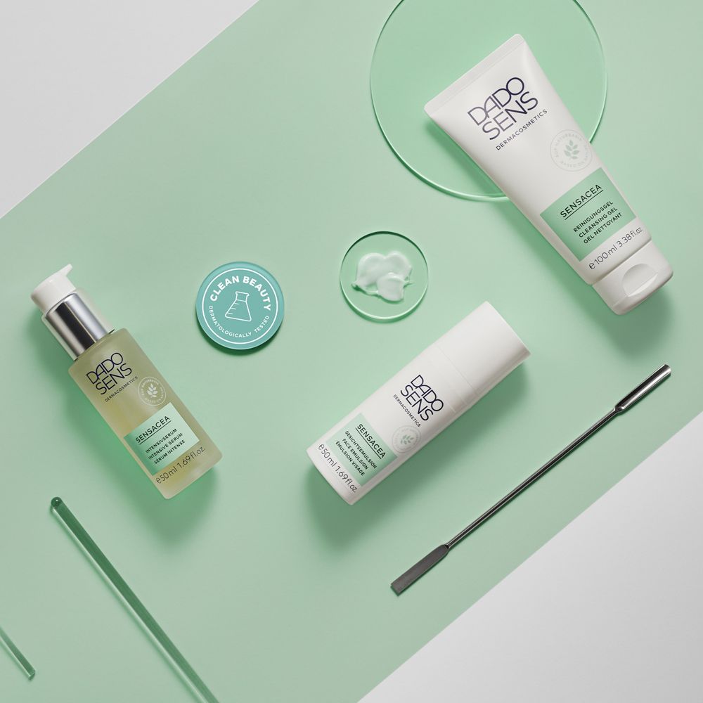 Produits DADO SENS : sérum, gel nettoyant, spatule, plaque de verre. Fond vert menthe.