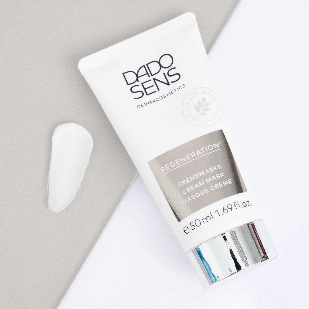 Tache de crème blanche sur fond gris-blanc. À côté, tube DADO SENS REGENERATION.
