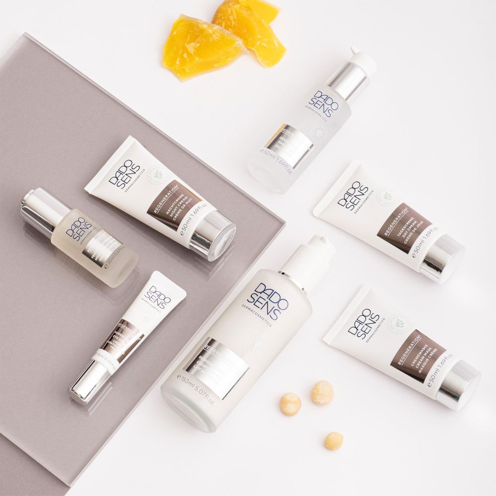Différents produits DADO SENS. Masques crème, sérums, flacons. Sur fond gris et blanc.