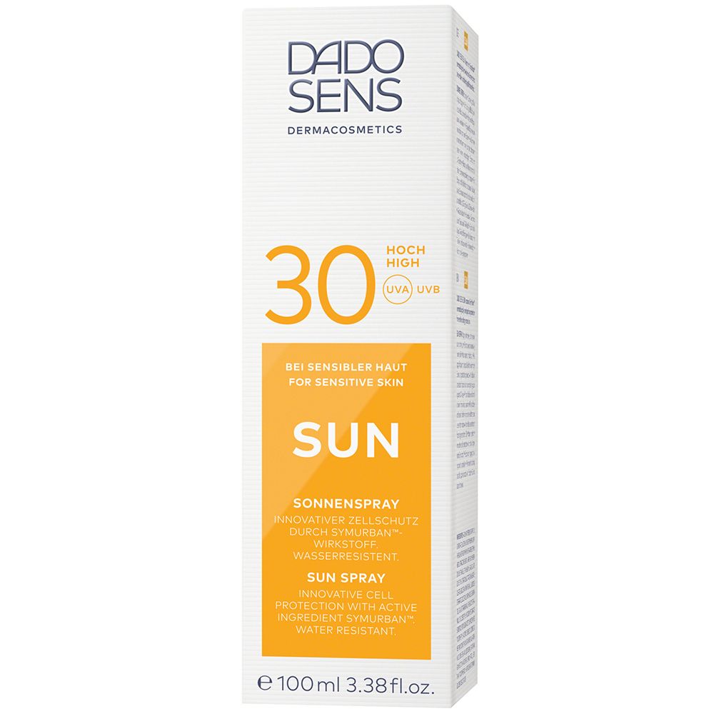 Emballage blanc, haut, avec spray solaire. Inscription : DADO SENS, 30, SUN, Sonnenspray. Autocollant jaune. 100ml. Texte en allemand et anglais.