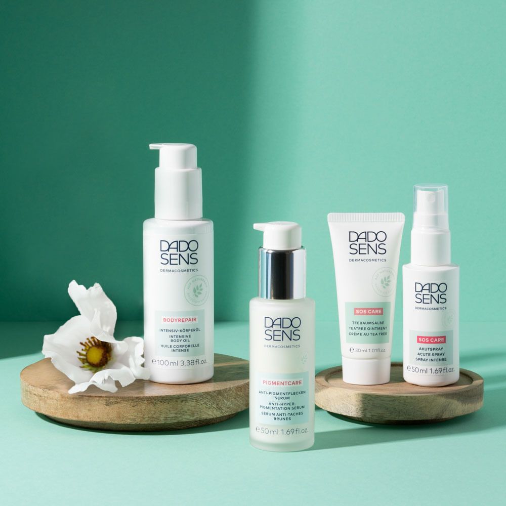 Quatre produits DADO SENS sur bois. Crèmes et lotions. Fond : turquoise.