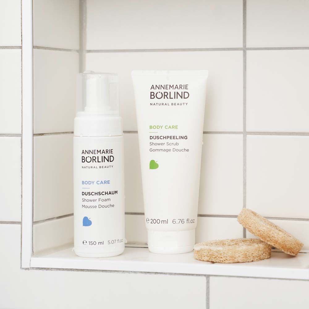 Flacon et tube blancs. Inscription : ANNEMARIE BÖRLIND, BODY CARE, DUSCHSCHAUM, 150 ml. Et gommage.