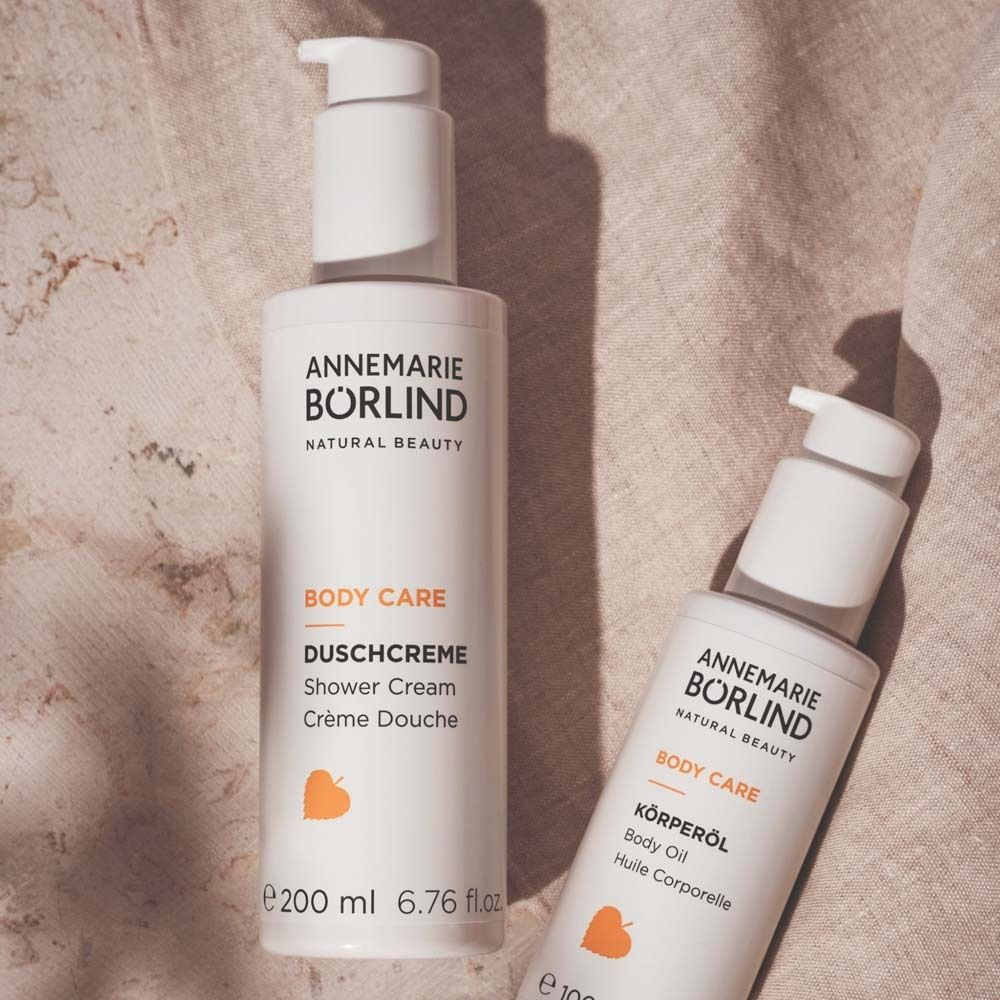 Deux flacons blancs avec pompe. Inscription : ANNEMARIE BÖRLIND, BODY CARE. Logo jaune.