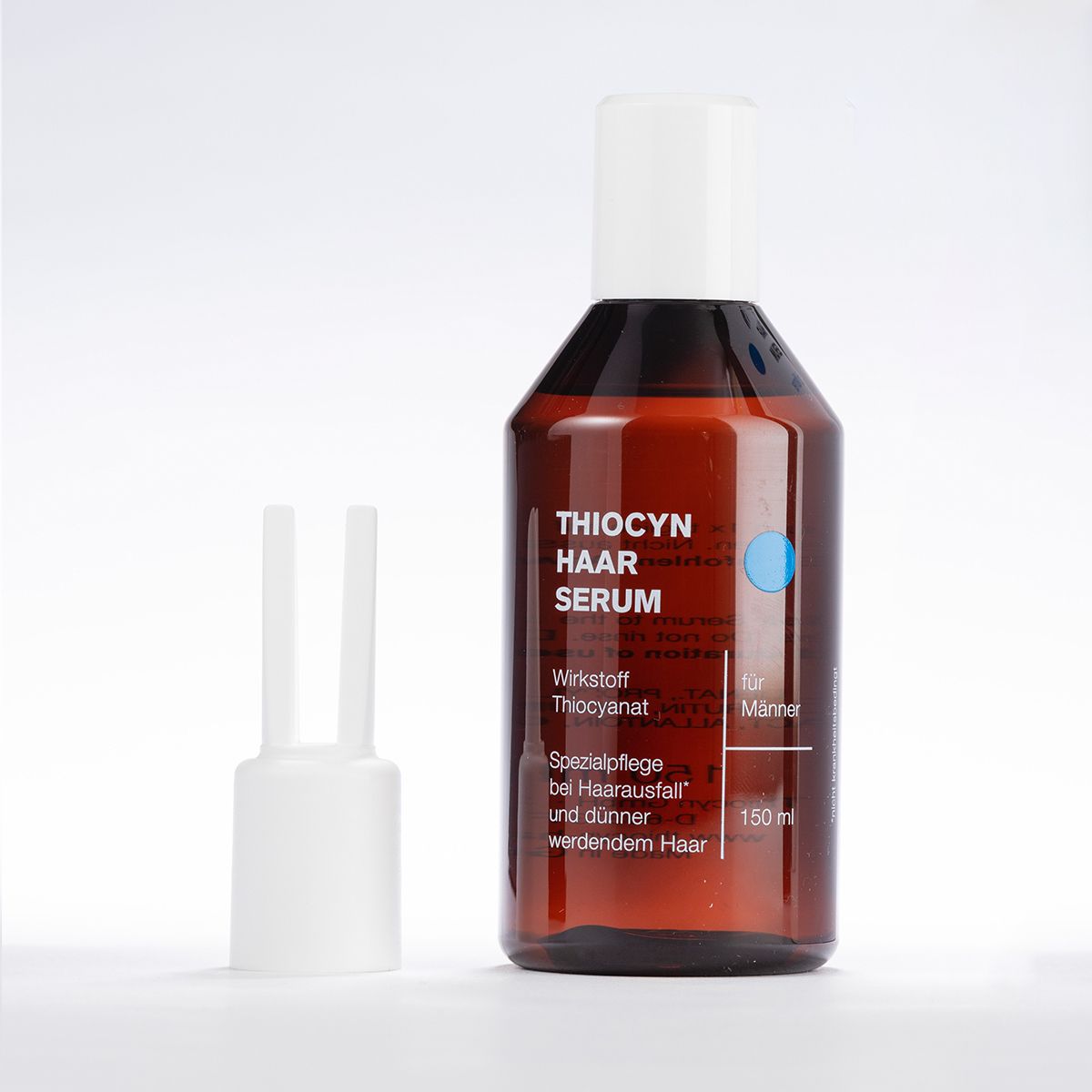 Flacon de sérum capillaire brun avec bouchon blanc et applicateur. Inscription : Thiocyn Haar Serum pour hommes.