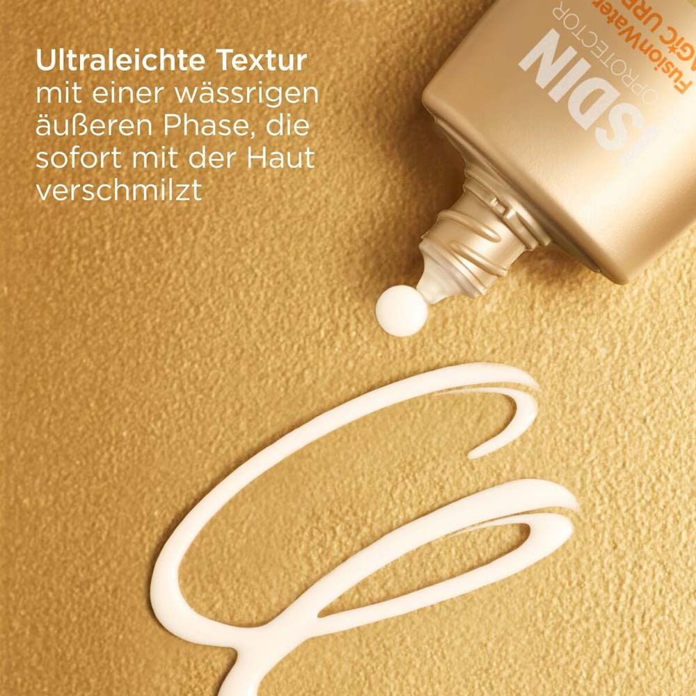 La crème solaire est versée d'un flacon doré sur une surface dorée. La texture est visible.