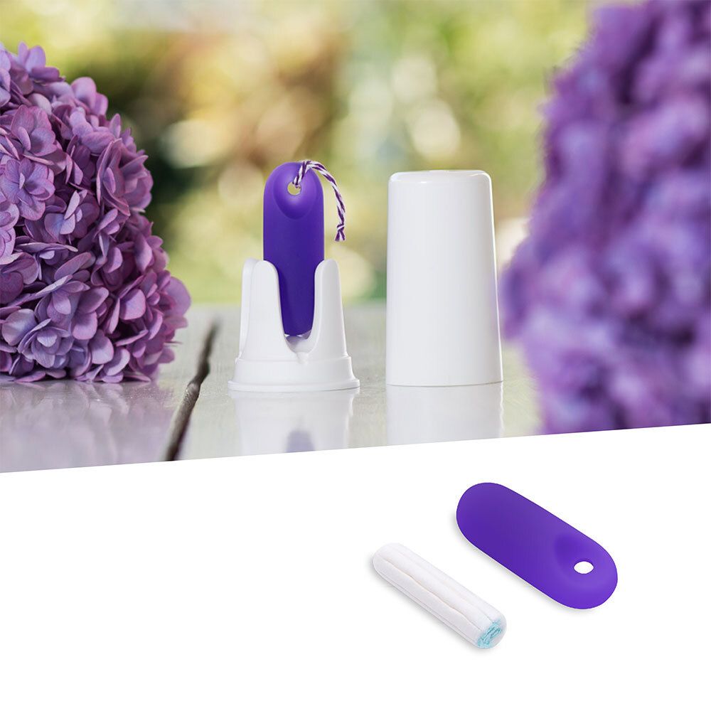Capteur violet avec cordon de rappel, support et capuchon blancs. Fond : fleurs.