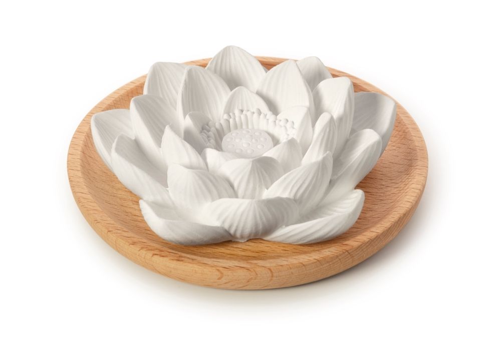 Pierre olfactive Lotusblüte blanche en forme de fleur de lotus sur une coupelle en bois. Fond blanc.