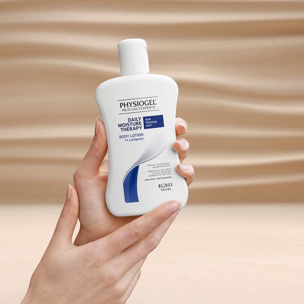 Mains tenant un flacon blanc de PHYSIOGEL® Daily Moisture Therapy Body Lotion. Forme arrondie.