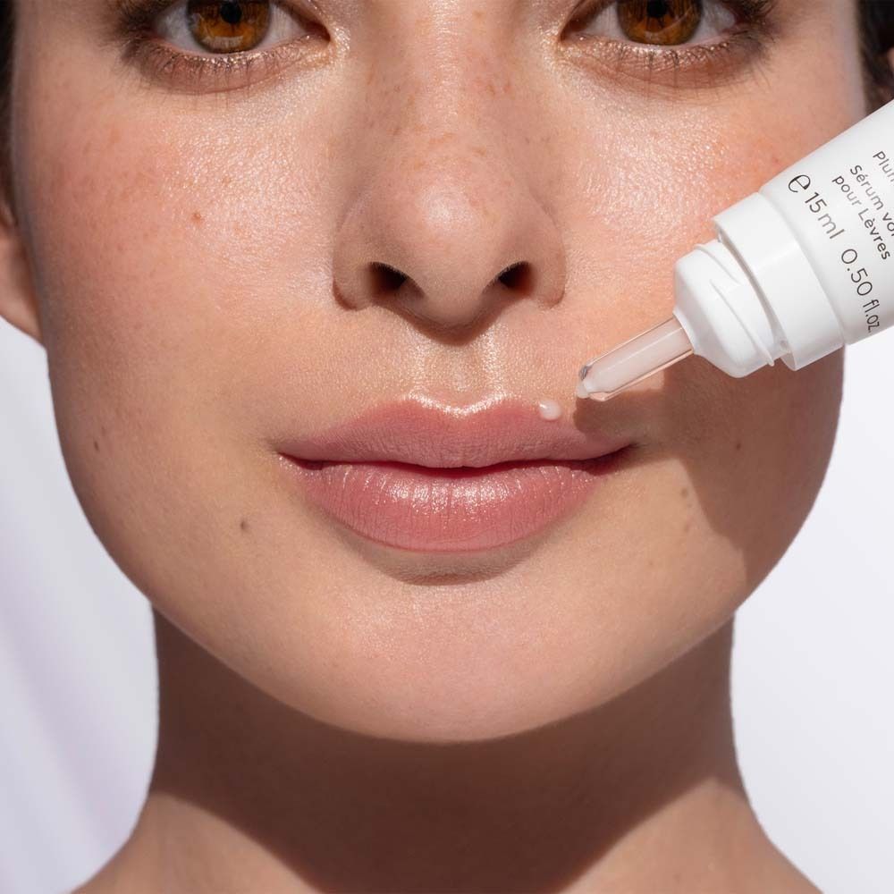 Femme avec sérum pour les lèvres. Le sérum est appliqué sur les lèvres. Nom du produit : NATU COLLAGEN BOOST. Marque : ANNEMARIE BÖRLIND.