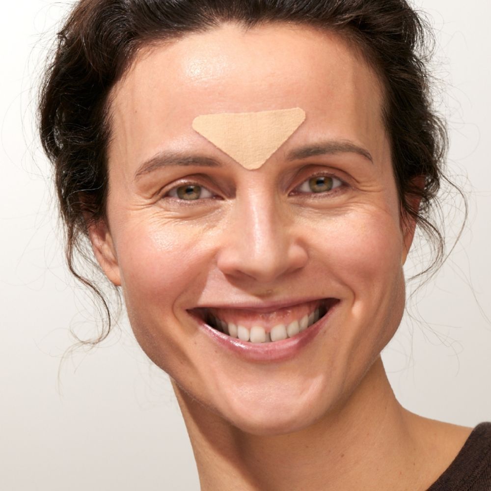 Femme avec un patch visage triangulaire entre les sourcils.