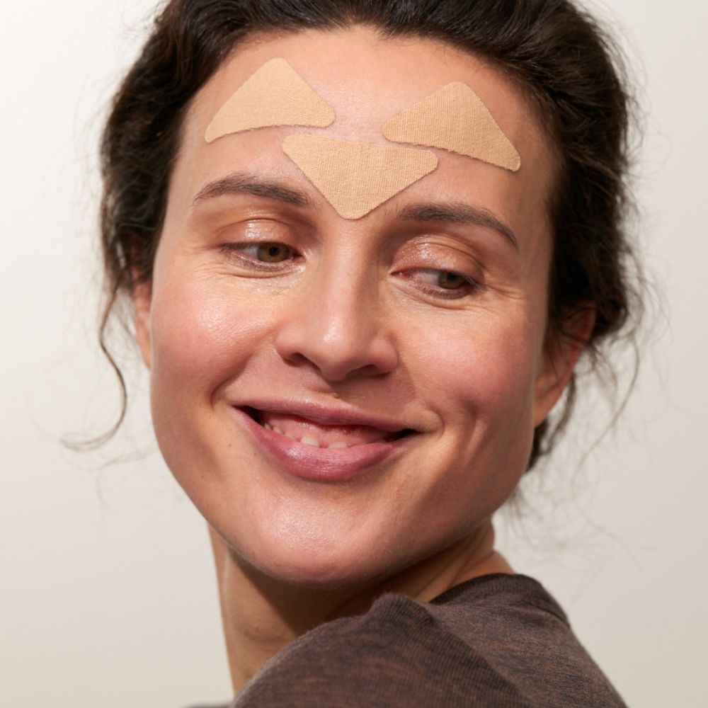 Femme avec trois patchs triangulaires sur le front.