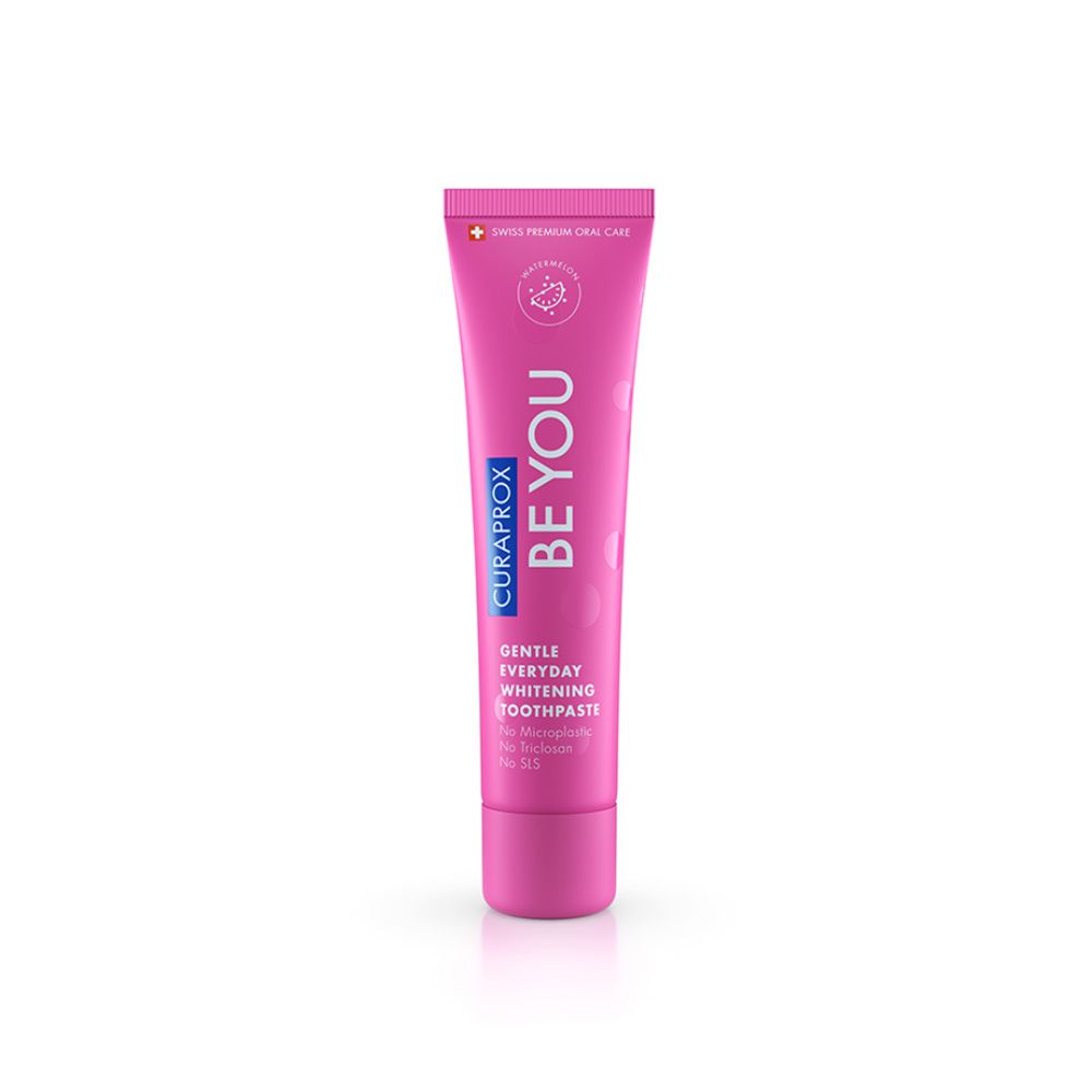 Tube rose avec texte blanc. Inscription: BE YOU, CURAPROX. Désignation du produit: Gentle Everyday Whitening Toothpaste.