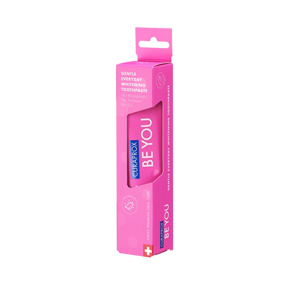 Emballage rose avec tube. Visible: BE YOU, CURAPROX. Désignation du produit: Gentle Everyday Whitening Toothpaste. Croix suisse.