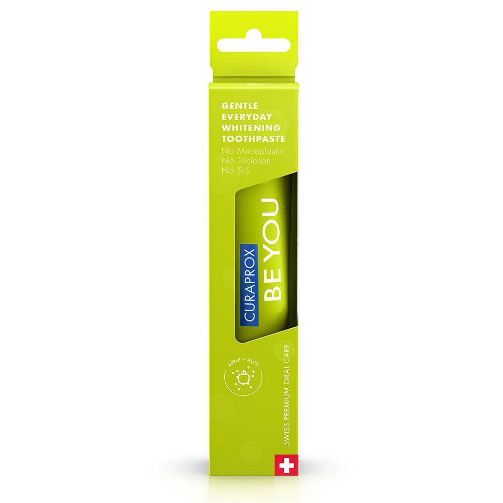 Tube de dentifrice dans un emballage jaune. Inscription : BE YOU, CURAPROX, Gentle Everyday Whitening Toothpaste. Croix suisse.