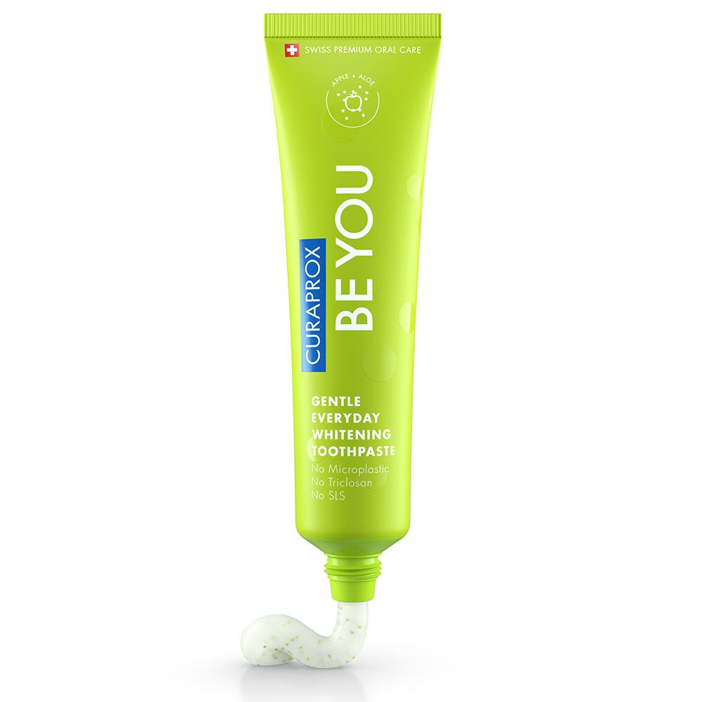 Tube de dentifrice vert avec pâte blanche. Inscription : BE YOU, CURAPROX, Gentle Everyday Whitening Toothpaste. Croix suisse.