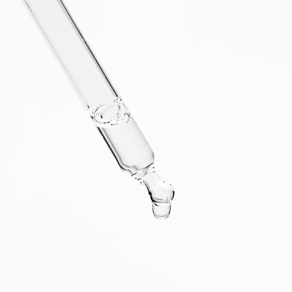Pipette en verre avec goutte de liquide au bout.