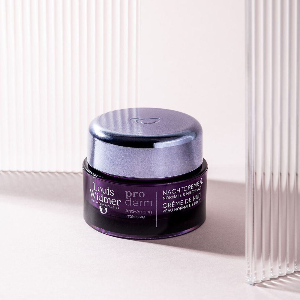 Louis Widmer pro derm Crème de Nuit dans un pot en verre violet, posé sur une surface claire.