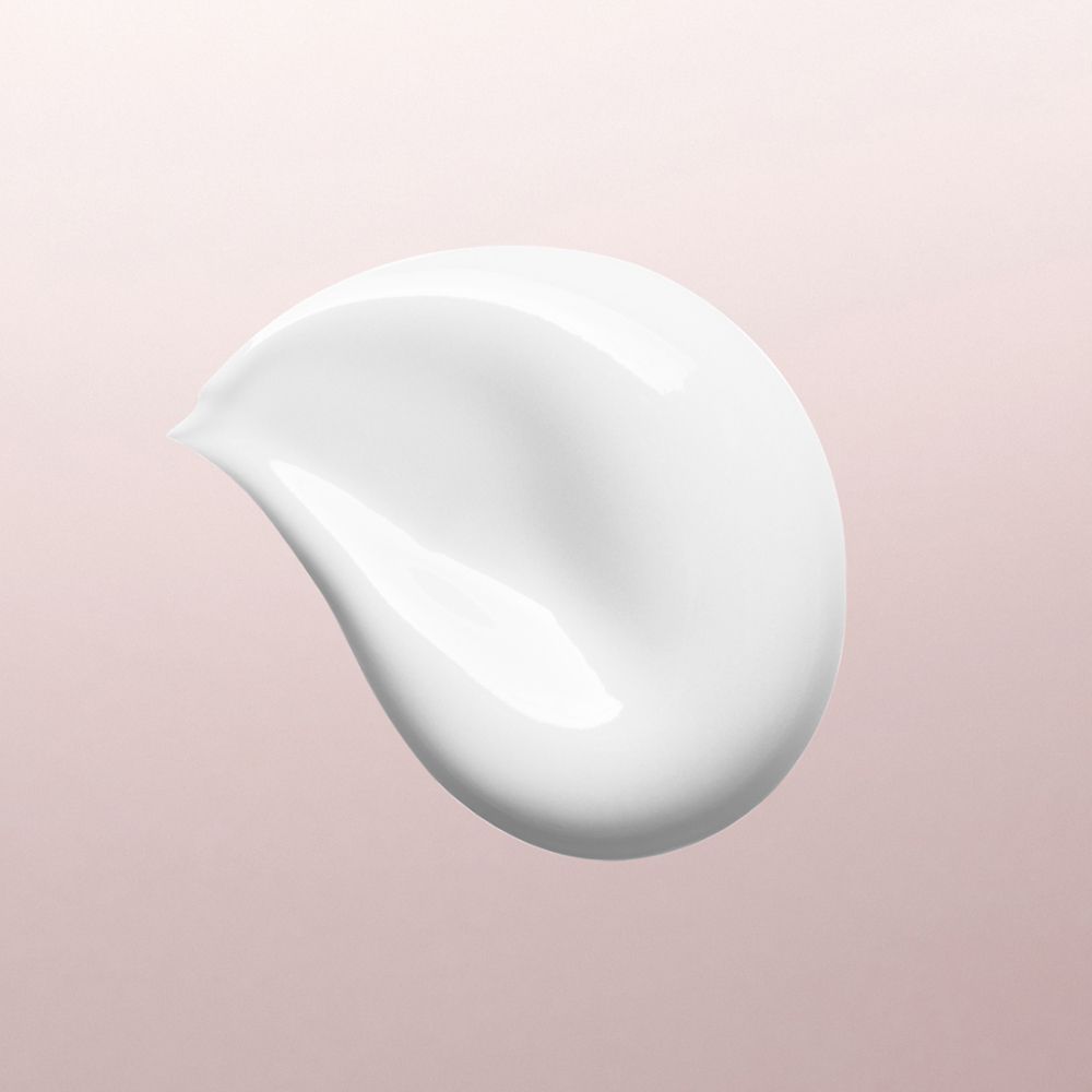 Un échantillon de crème blanche sur un fond rose.