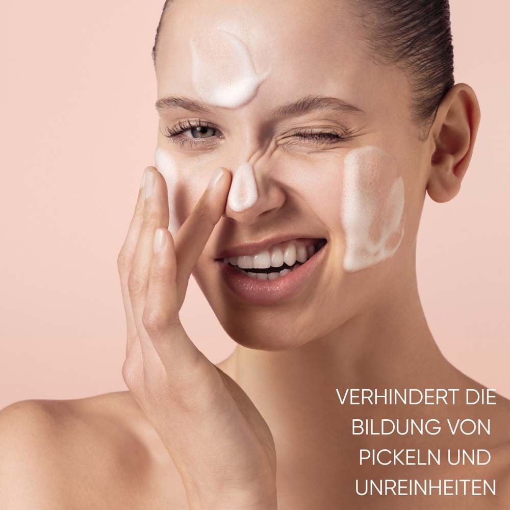 Femme avec mousse sur le visage. Texte: Prévient l'apparition de boutons et d'imperfections.