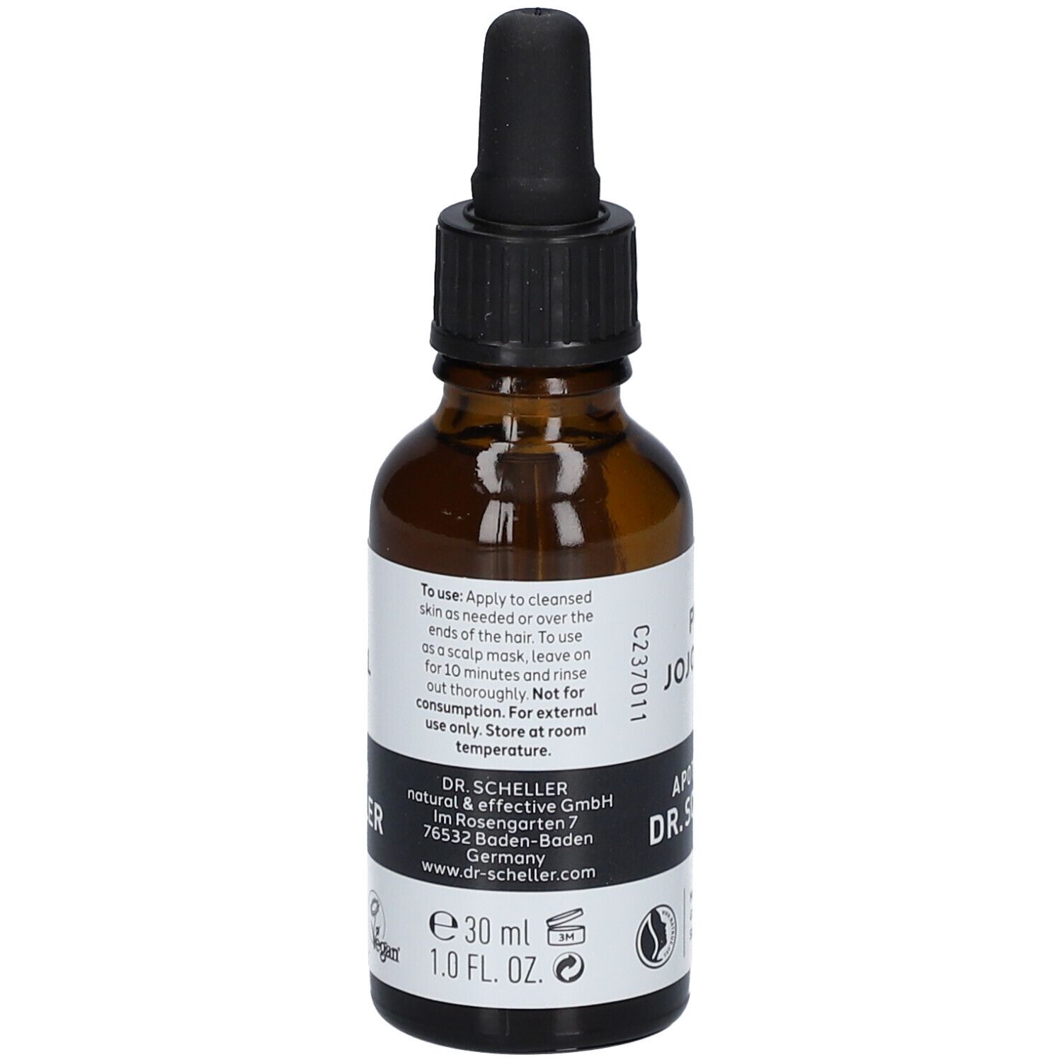 Flacon en verre brun avec pipette. Étiquette avec texte: PURE JOJOBA OIL, Apotheker DR.SCHELLER. Vegan. Fabriqué en Allemagne. Avec mode d'emploi.