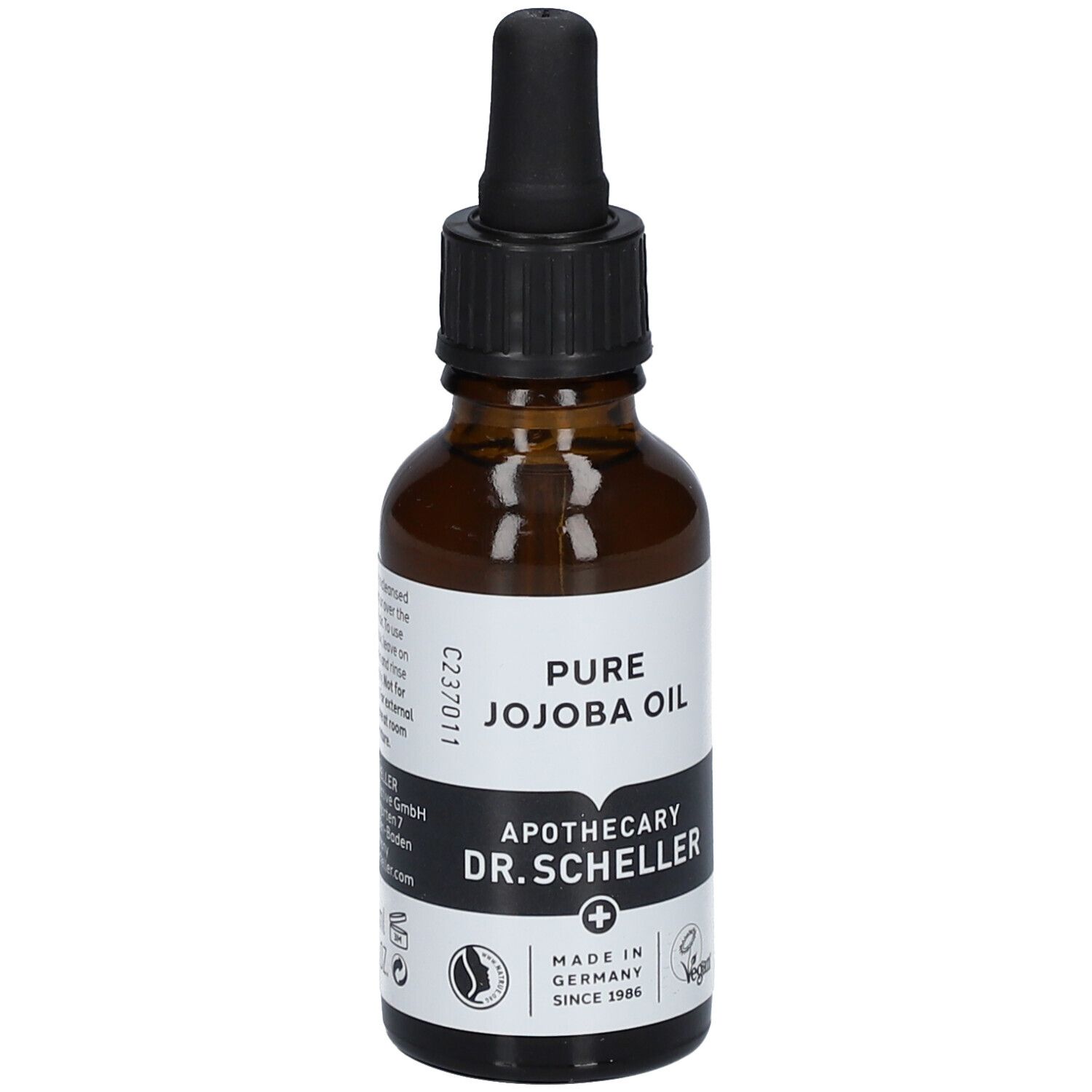Flacon en verre brun avec pipette. Étiquette avec texte: PURE JOJOBA OIL, Apotheker DR.SCHELLER. Vegan. Fabriqué en Allemagne.