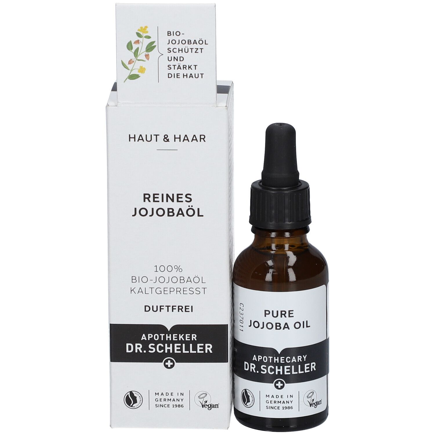Flacon en verre brun avec pipette et emballage. Étiquette avec texte: REINES JOJOBAÖL, Apotheker DR.SCHELLER. Vegan. Fabriqué en Allemagne.