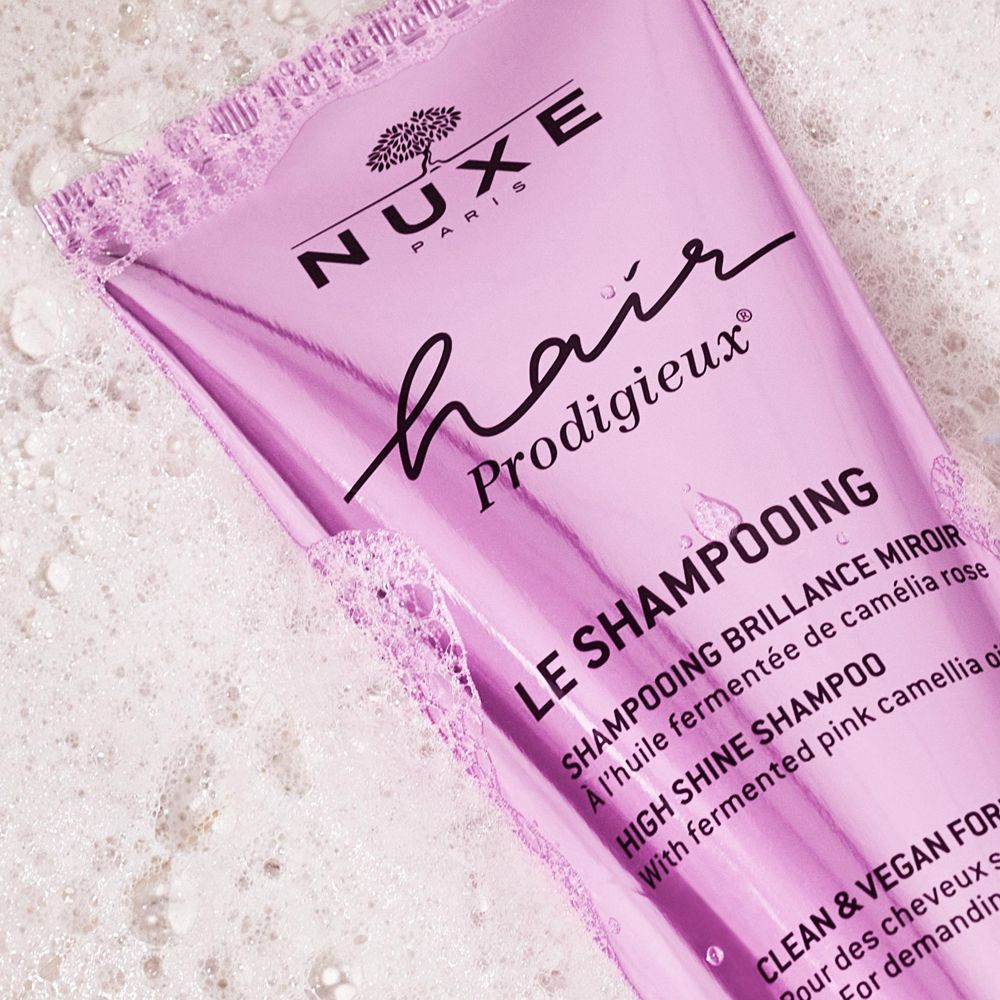 Gros plan sur un tube de shampooing NUXE Hair Prodigieux. Nom du produit et mousse.
