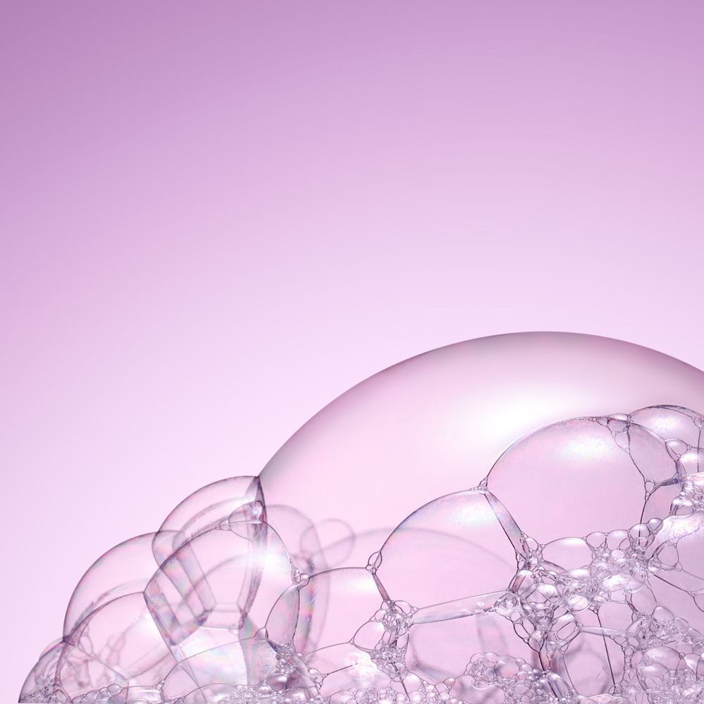 Gros plan sur des bulles de savon sur fond rose.