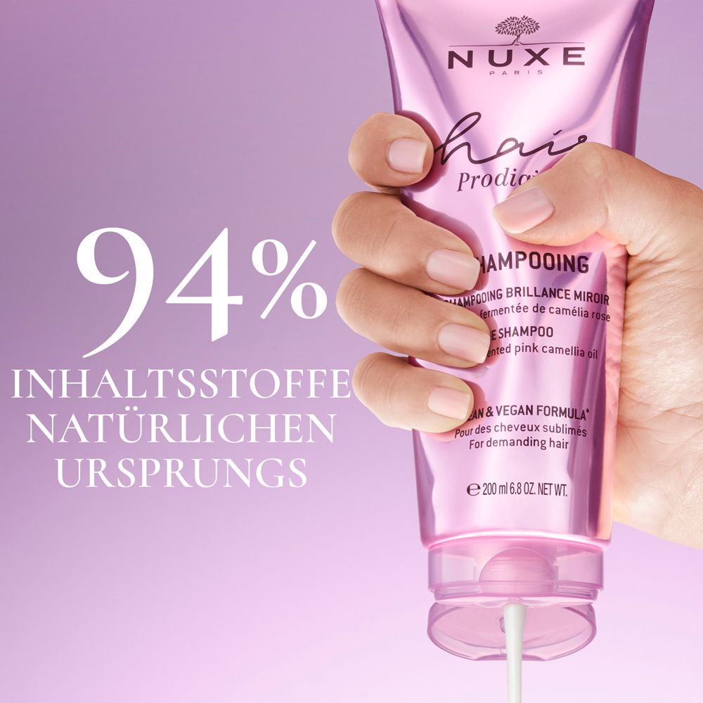 Main tenant un tube de shampooing NUXE Hair Prodigieux. Texte : 94% d'ingrédients d'origine naturelle.