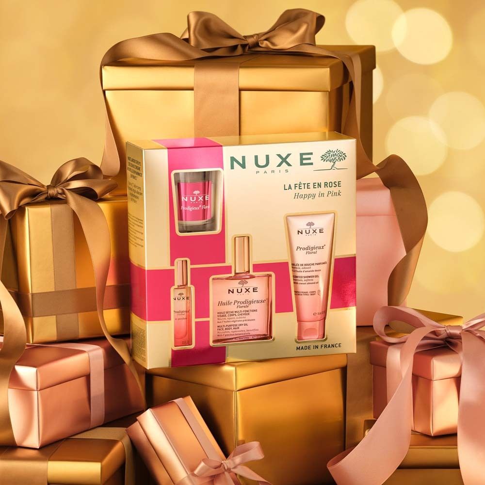 Coffret cadeau NUXE entouré de boîtes et rubans dorés. Contient plusieurs produits.
