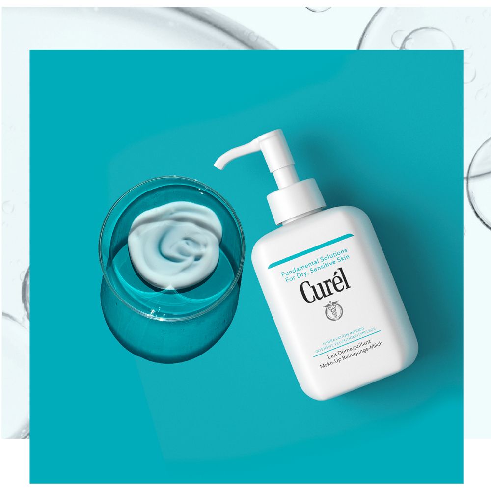Distributeur blanc avec pompe et produit sur fond bleu. Produit dans un bol.