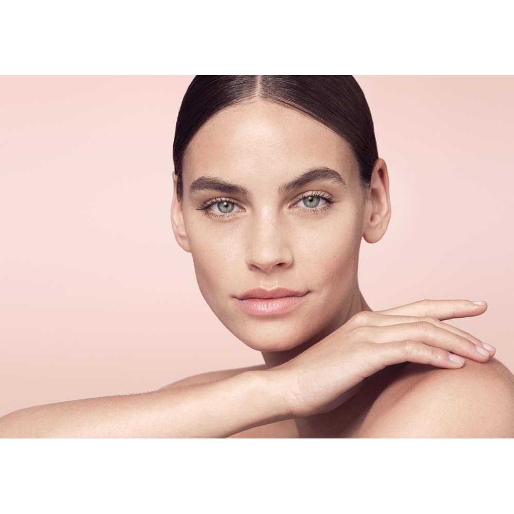 Portrait d'une femme avec une peau propre. Elle touche son visage avec sa main.
