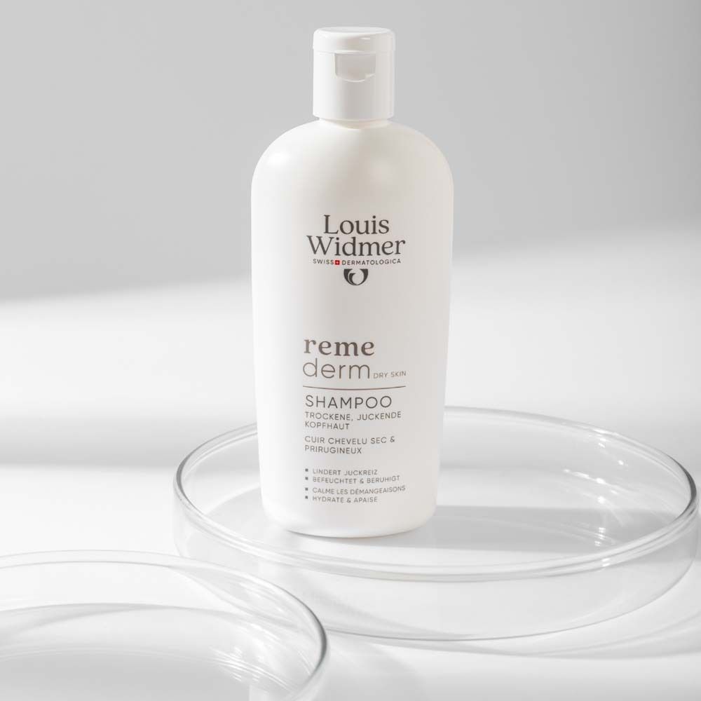 Flacon de shampooing blanc sur plaque de verre. Marque Louis Widmer, remederm. Texte: Shampooing, cuir chevelu sec et prurigineux.