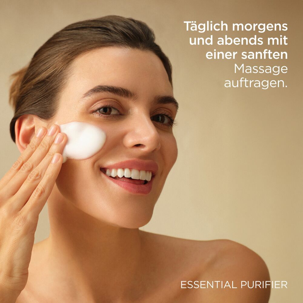 Femme appliquant de la mousse. Texte : Appliquer matin et soir avec un massage doux. ESSENTIAL PURIFIER.