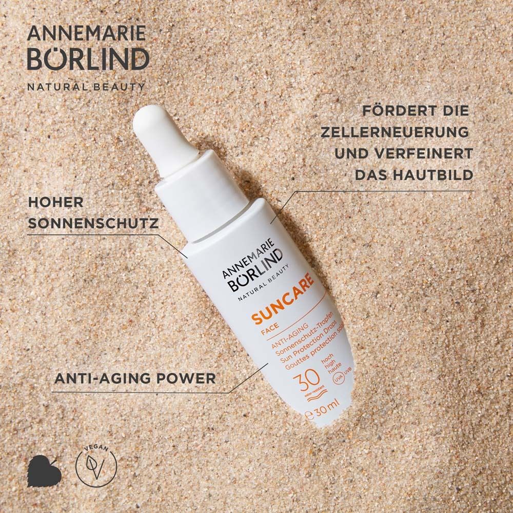 Flacon avec pipette sur sable. Inscription : Suncare Face, Anti-Âge, SPF 30. Texte : Haute protection solaire.