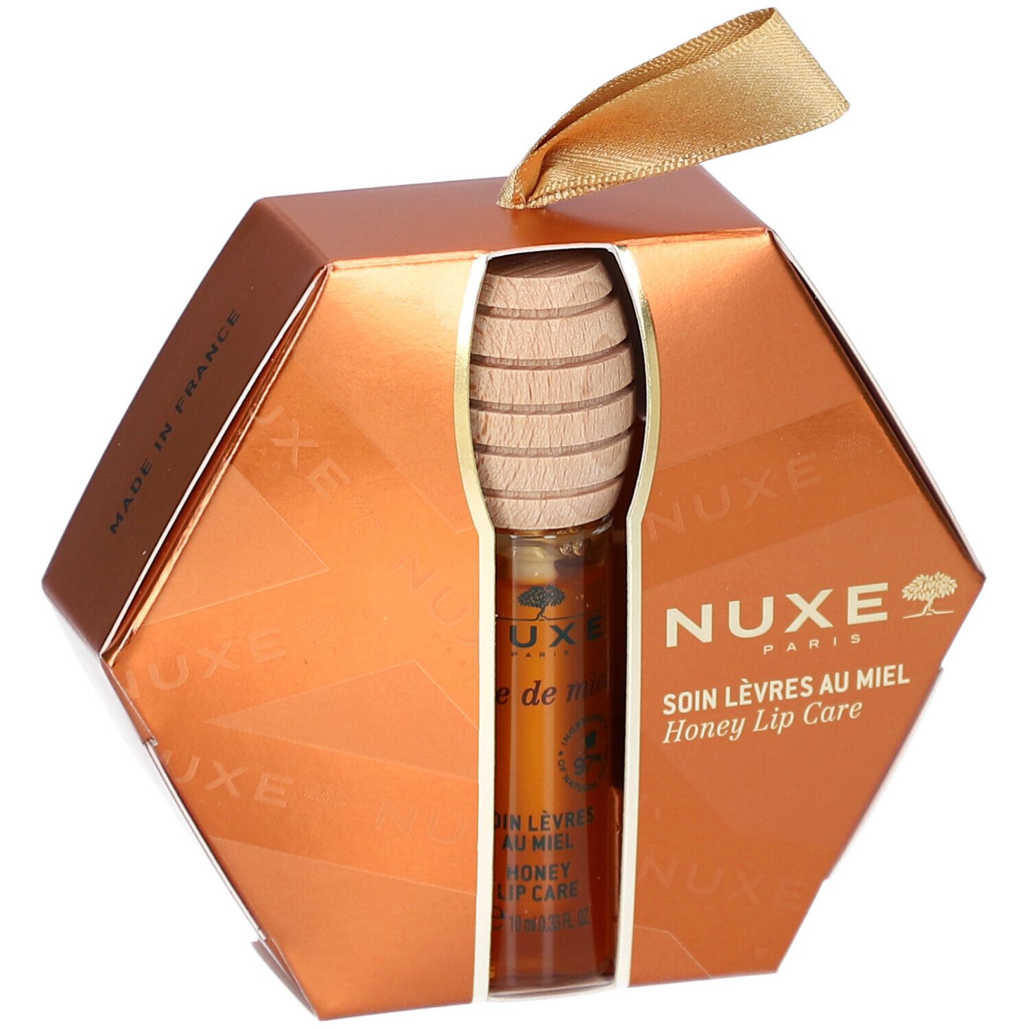 Coffret cadeau soin des lèvres au miel. Emballage hexagonal doré. Produit et cuillère à miel visibles. Logo NUXE.