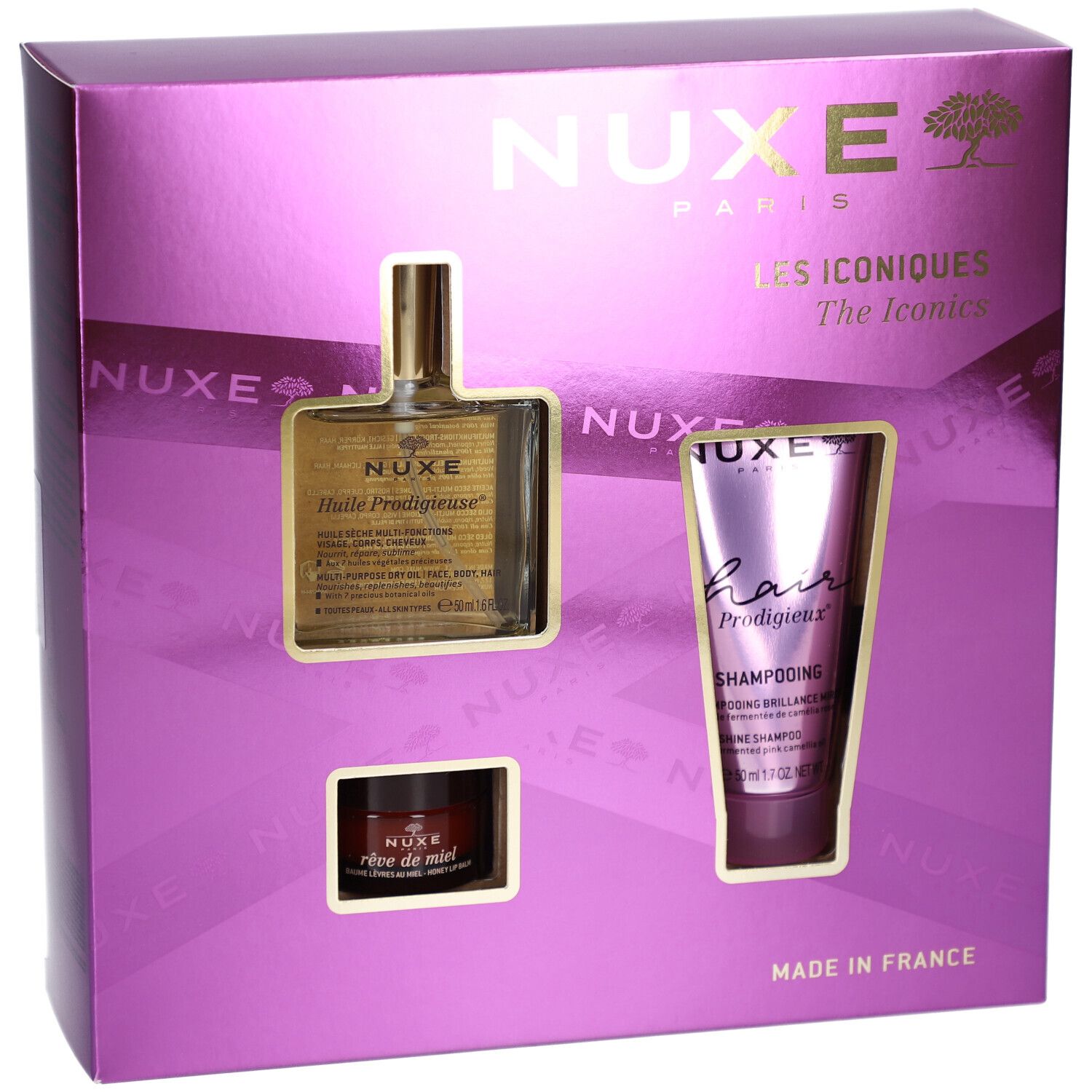 Coffret cadeau violet avec trois produits : huile, shampooing et crème. Le nom de la marque NUXE est visible. "Les Iconiques" est inscrit.
