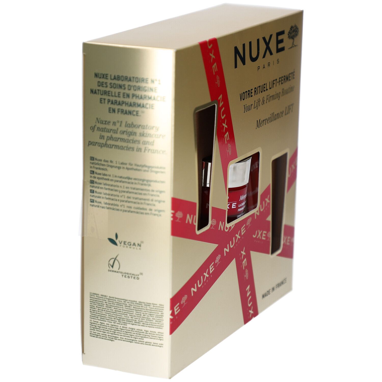 Vue latérale du coffret cadeau. Doré avec ruban rouge et fenêtres produits. Logo NUXE et texte. Logo Vegan.