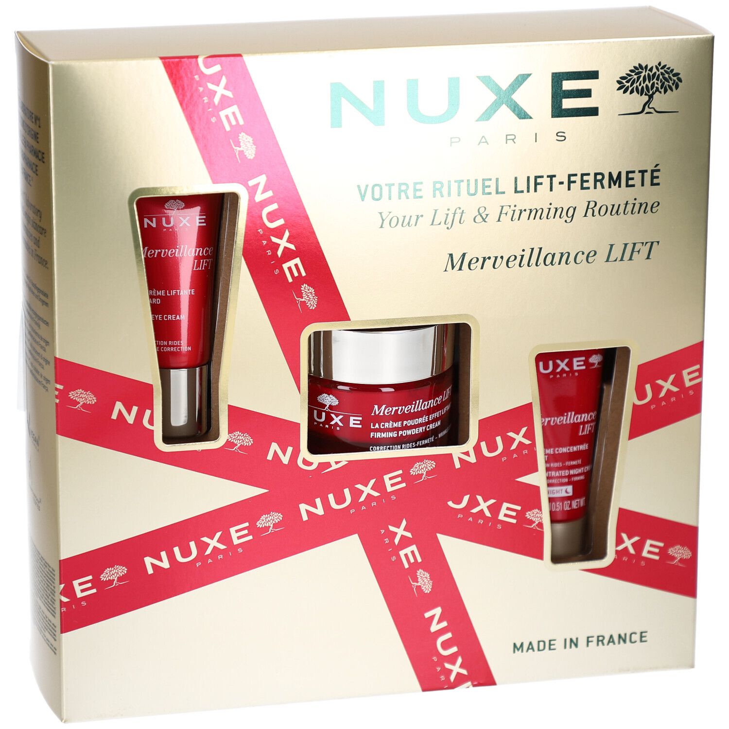 Coffret cadeau avec trois produits cosmétiques. Boîte dorée avec ruban rouge et fenêtres produits. Logo NUXE.