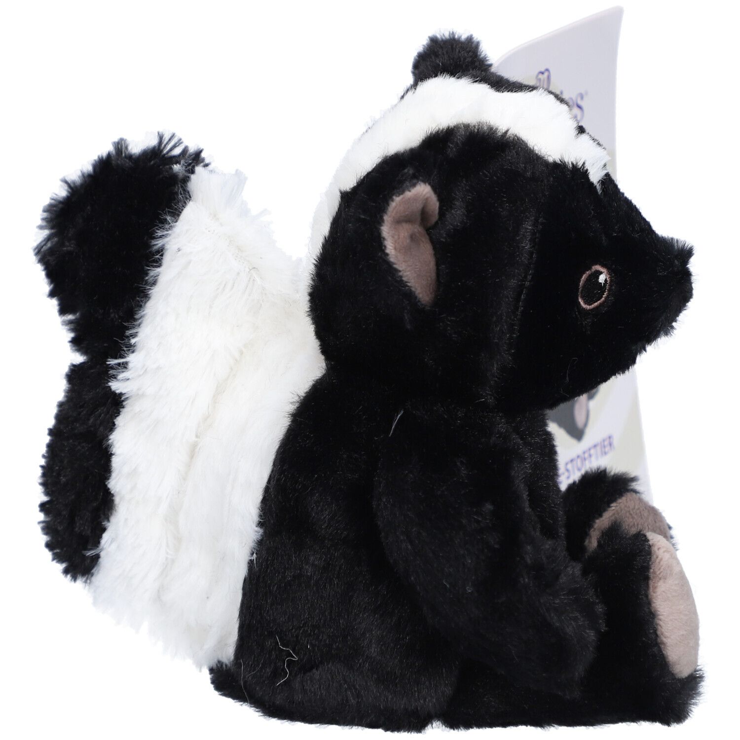 Vue latérale d'une peluche de mouffette noire et blanche. Une étiquette est visible en arrière-plan.