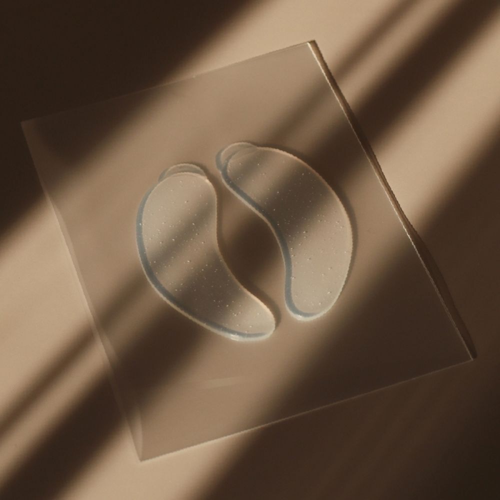Deux coussinets pour les yeux transparents sur une surface transparente. Légèrement inclinés à la lumière.