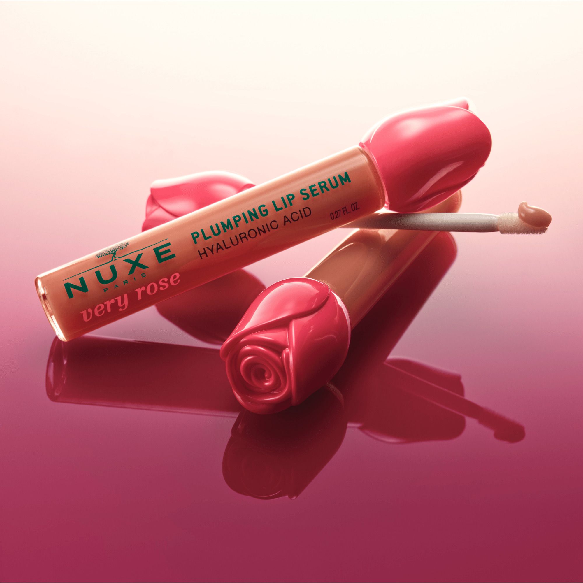 Deux tubes de sérum à lèvres avec bouchons en forme de rose. Texte: Plumping Lip Serum, Hyaluronic Acid, Very Rose.