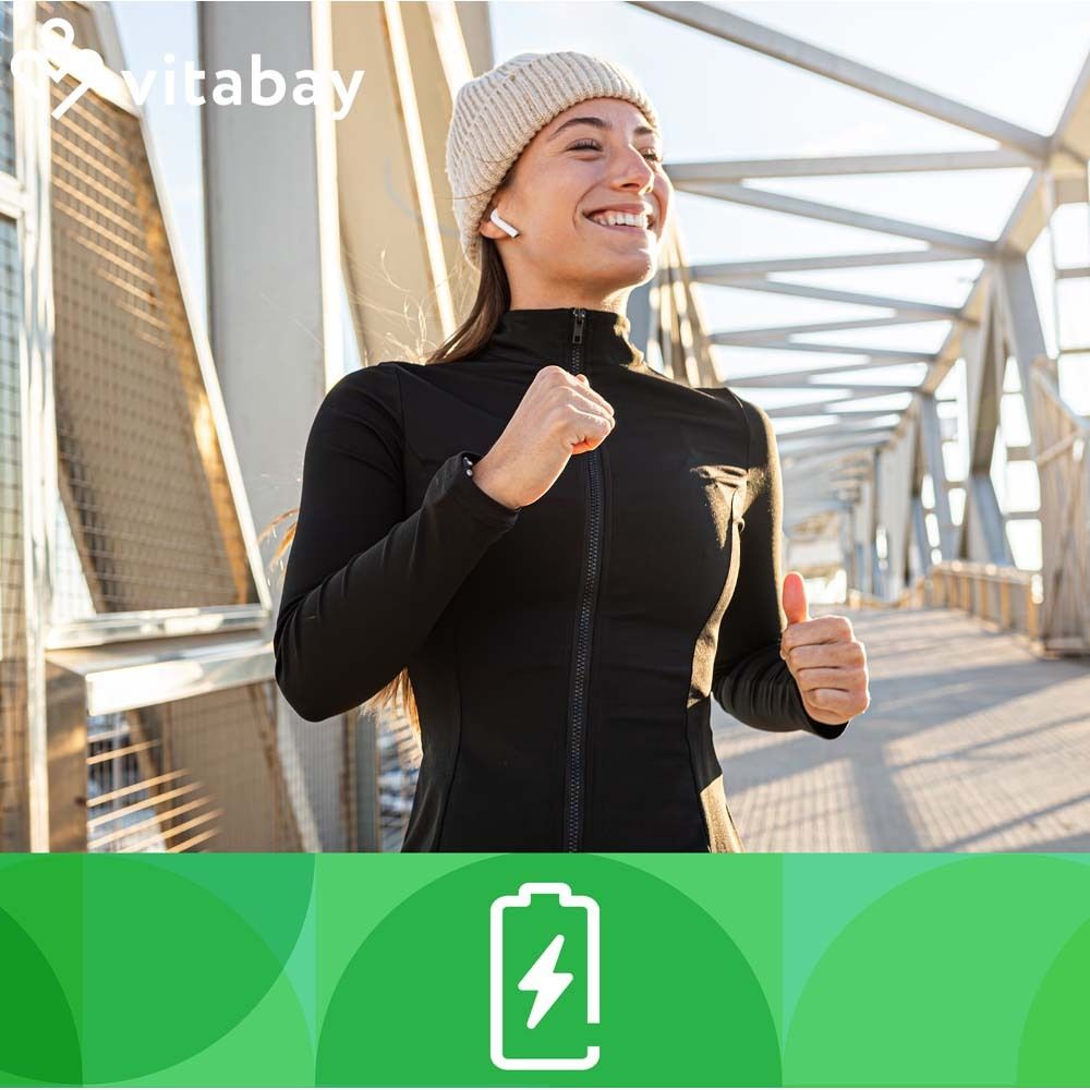 Femme souriante sur un pont. Vêtements de sport. Logo Vitabay en haut. Fond vert avec symbole de batterie blanc.