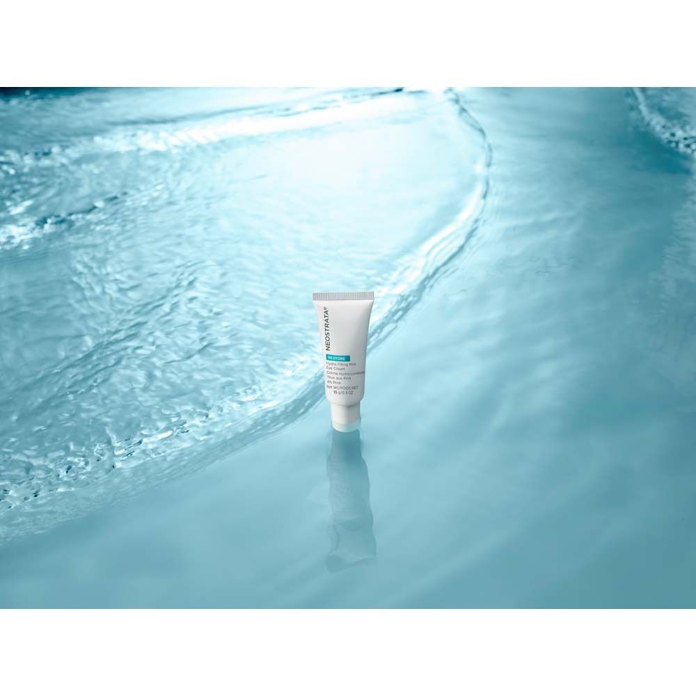 Tube blanc NeoStrata Restore Eye Cream dans l'eau bleue. Nom et détails du produit visibles.