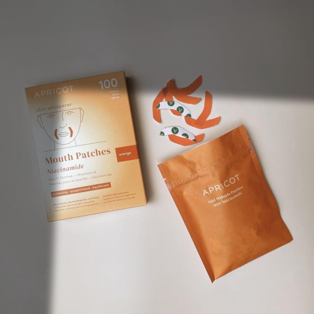 APRICOT Mouth Patches Niacinamide : boîte, pochette et patchs dispersés sur fond clair.