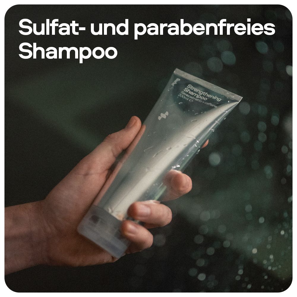 Main tenant un tube de shampooing fortifiant Sons sous la douche.